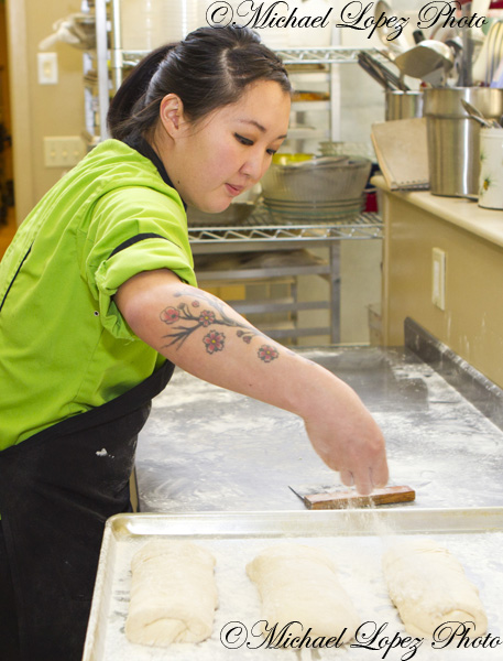 Mandi Wendt sprinkles powder on top of the Ciabatta's  at the Weinhard Cafe in Dayton, Wa. The process to make Ciabatta's takes 24 hours, from preparing the dough to the moment it comes out of the oven.